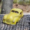 Kleines gelbes Auto auf einem Baumstumpf